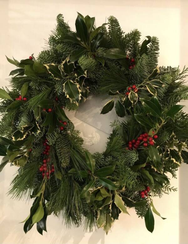 Traditional Christmas door wreath full of festive foliage and red berries